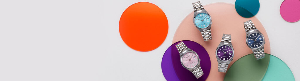 Image of four TSUYOSA 37mm models laying on top a colorful circles background. Image features watch models NJ0200-50L, NJ0200-50Z, NJ0200-50W and NJ0200-50M